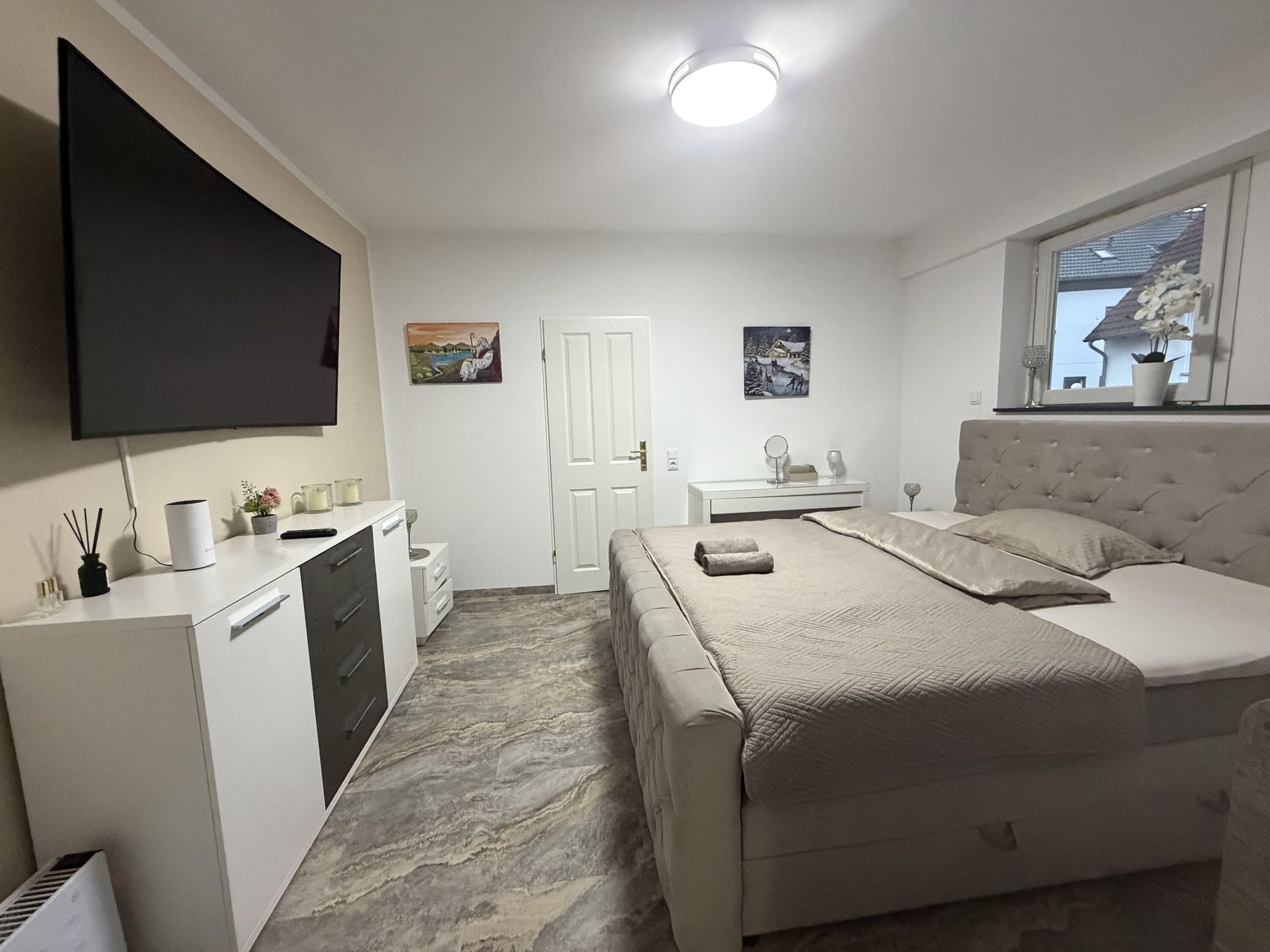 Schlafzimmer mit Bett und Wand-TV