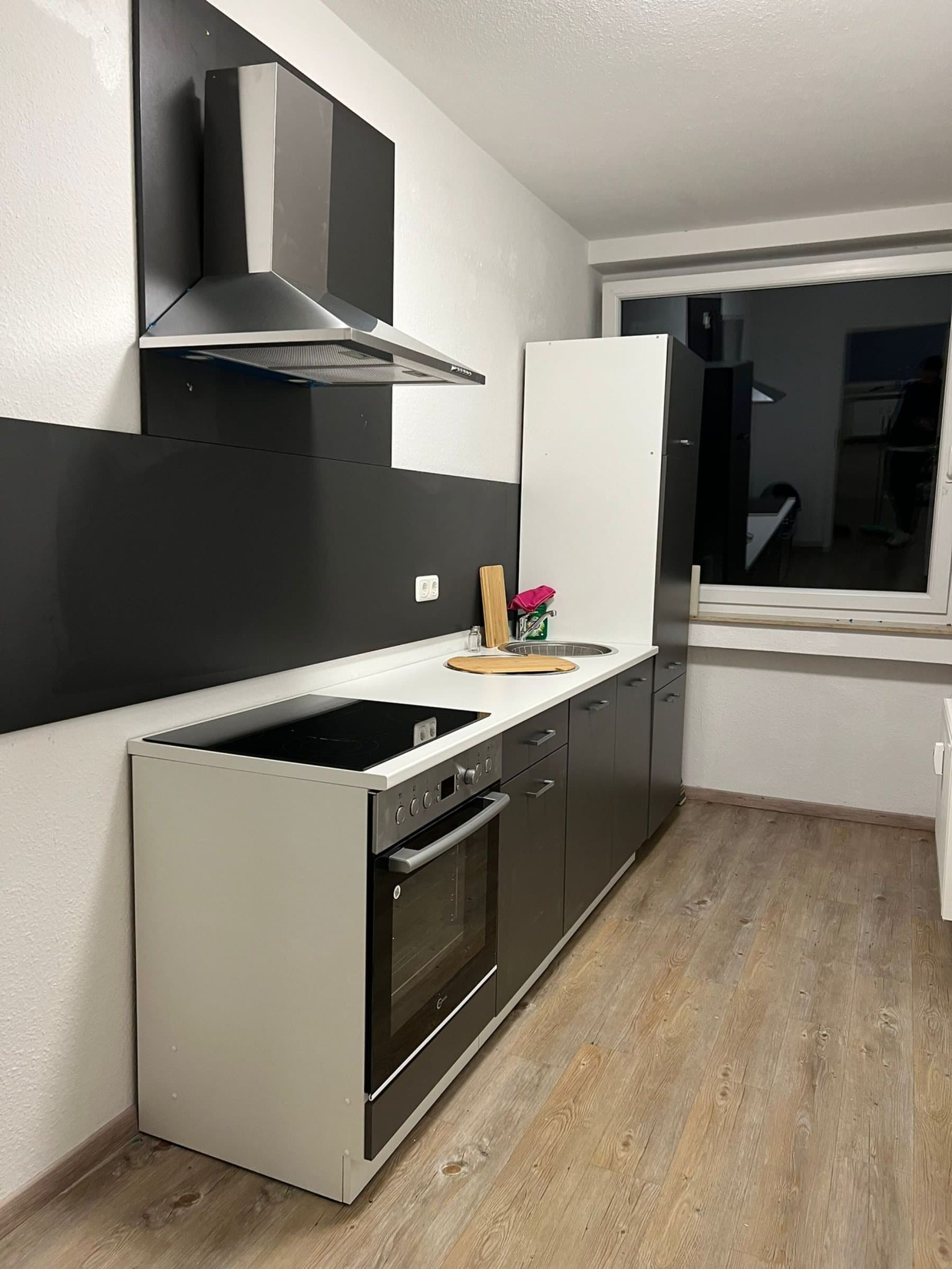 Küche mit Herd, Backofen und Dunstabzug