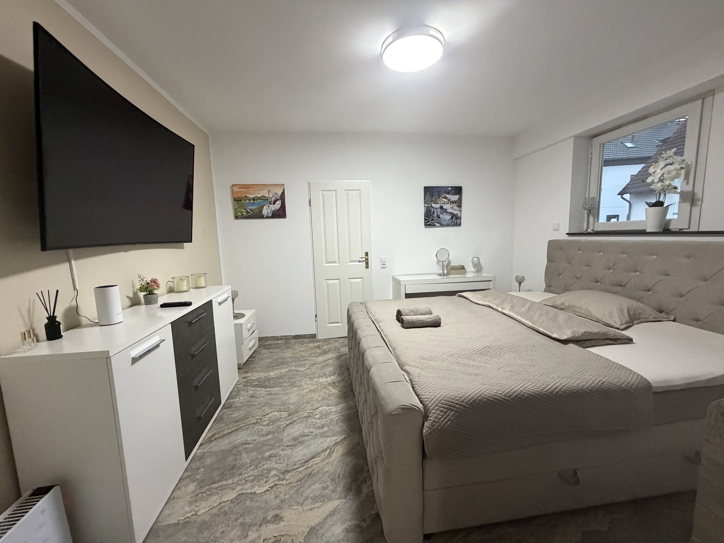 Schlafzimmer mit Bett und Wand-TV