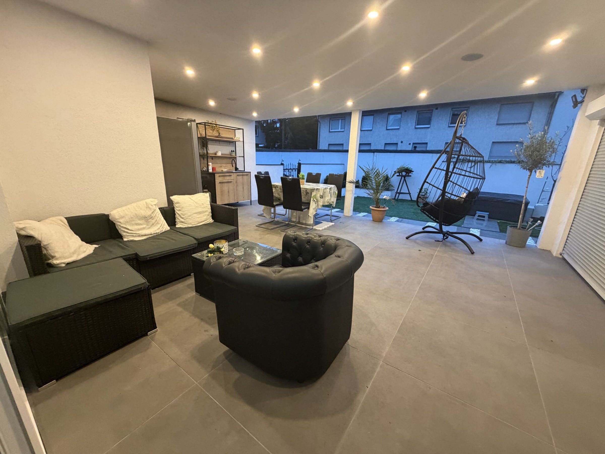 Lounge-Raum mit Sofa und TV an der Terrasse