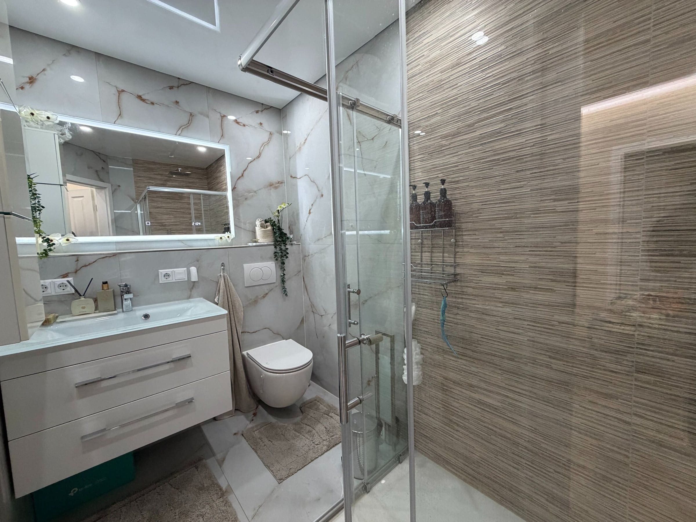 Badezimmer mit Glasdusche und Waschtisch