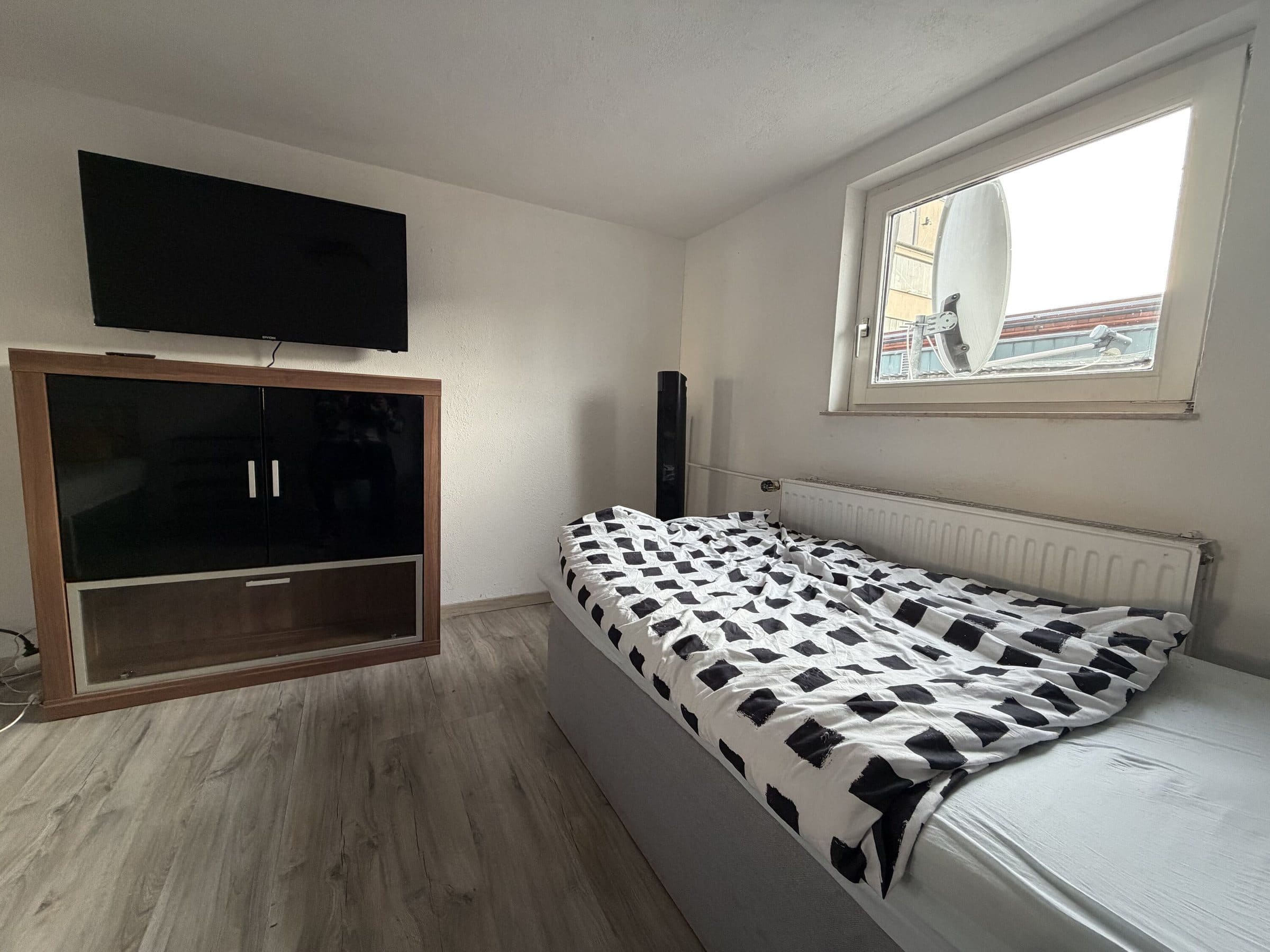 Schlafzimmer mit Bett, Schrank und Fernseher