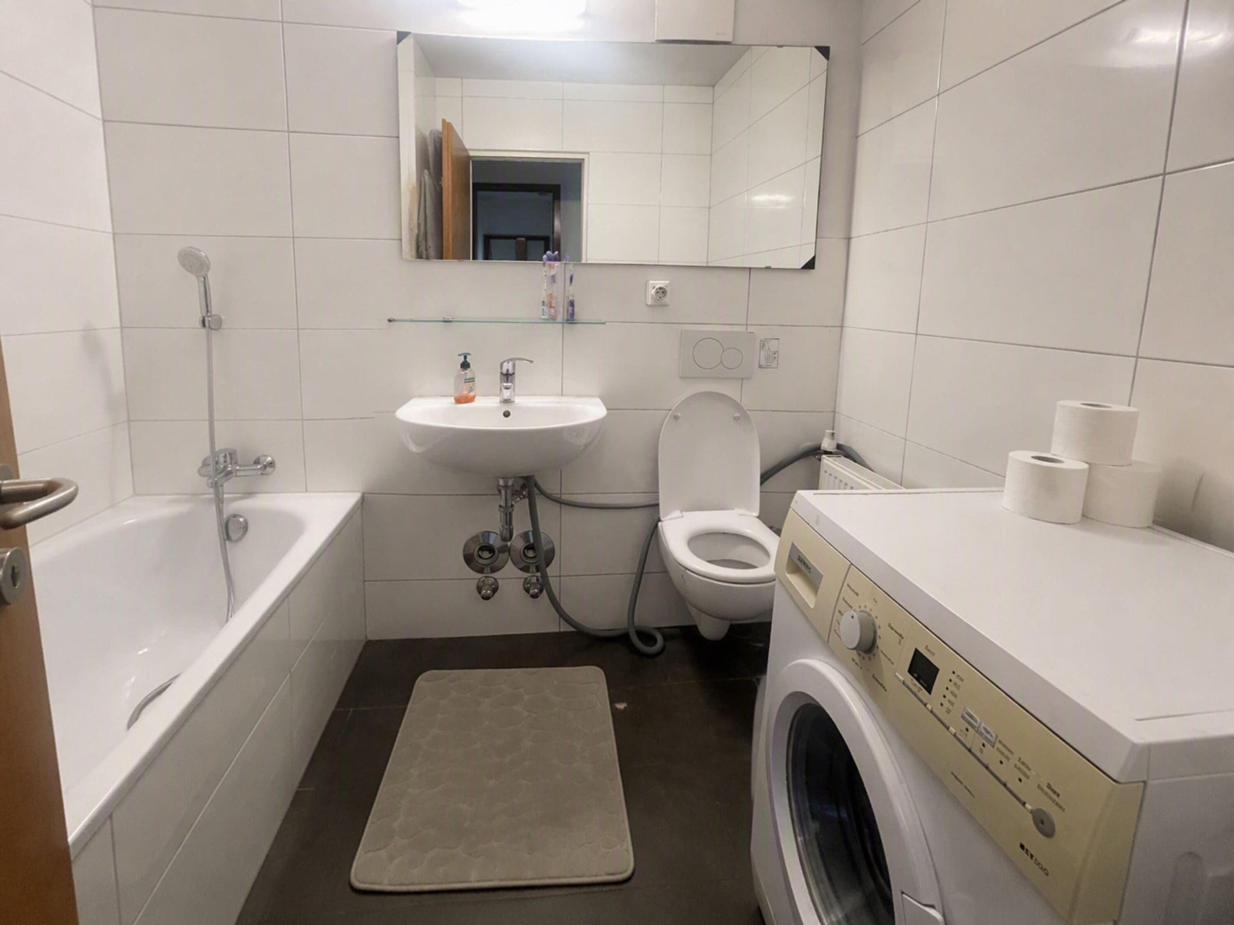 Badezimmer mit Badewanne und Waschmaschine